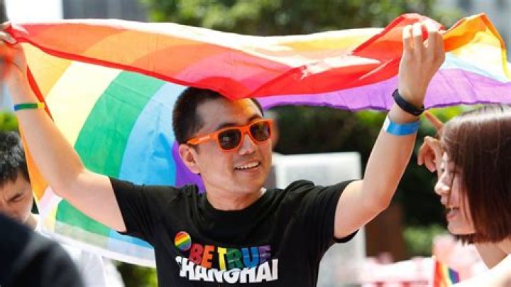 A Man Holds A Rainbow Flag